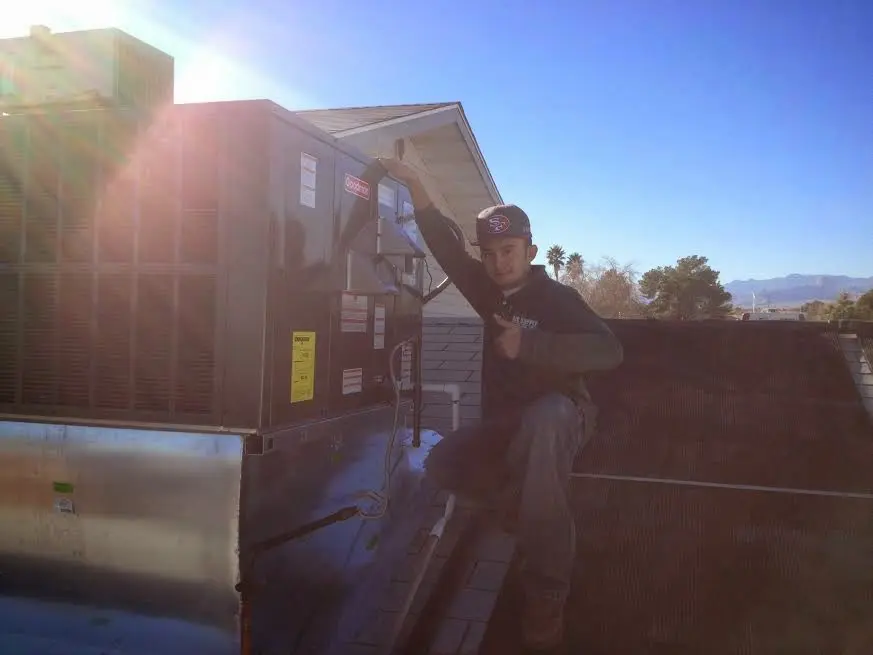 HVAC technician performing Boiler Repair on a rooftop unit in Cedar Hills
